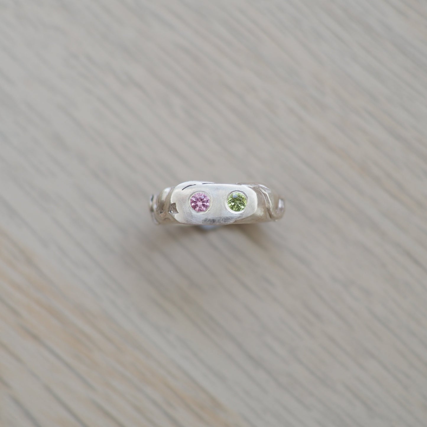 Small decorative item with natural topaz and peridot gemstones on a textured  vine leaf surface