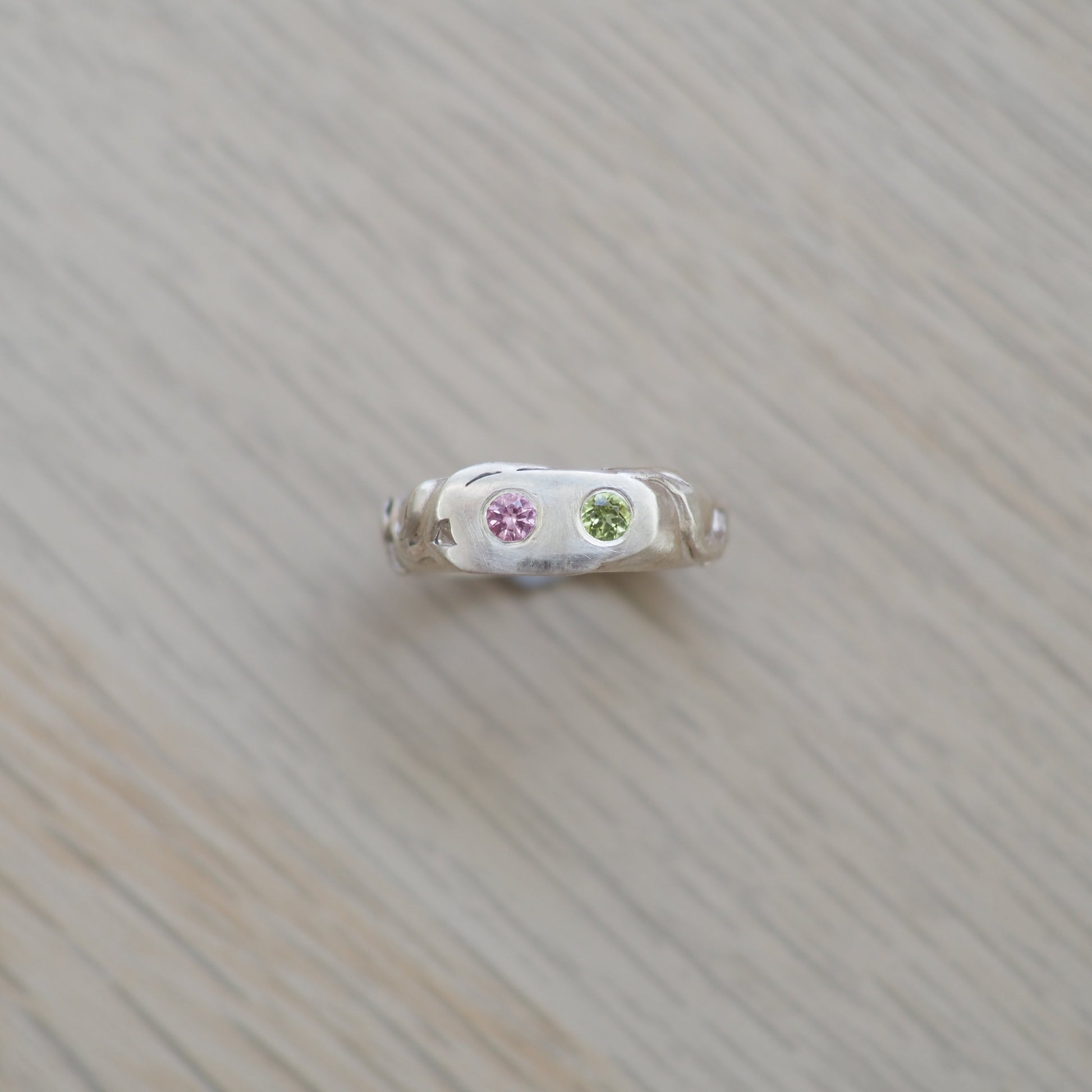 Small decorative item with natural topaz and peridot gemstones on a textured  vine leaf surface